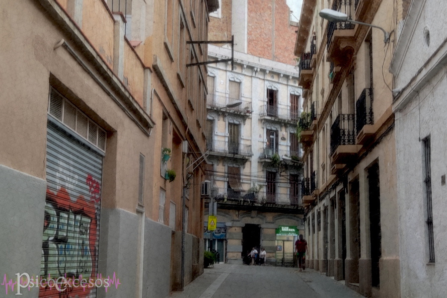 Vista de un callejón encerrado por edificios antiguos con balcones