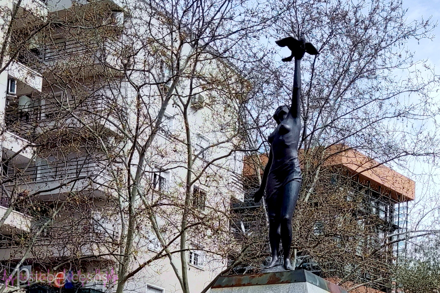 Estatua de una mujer lanzando un ave al cielo